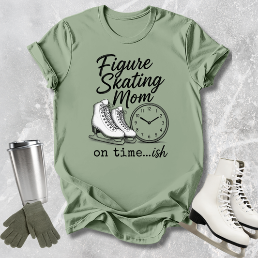 Green t-shirt with figure skating mom graphic and accessories on a textured surface