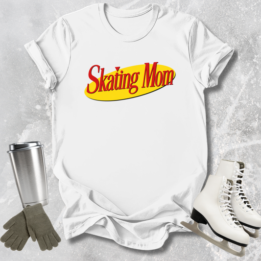 White t-shirt with 'Skating Mom' text, silver tumbler, gray gloves, and white skates on a textured gray background