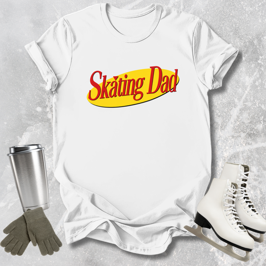 White t-shirt with 'Skating Dad' text, silver tumbler, gray gloves, and white skates on a textured gray background