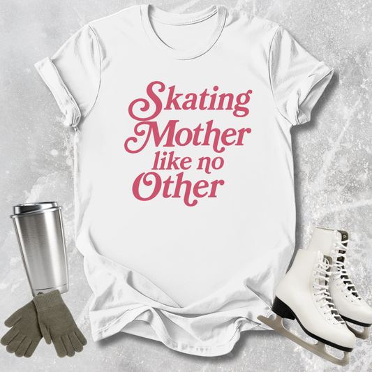 White t-shirt with pink text 'Skating Mother like no Other', next to ice skates, gloves, and a tumbler on a textured gray background.