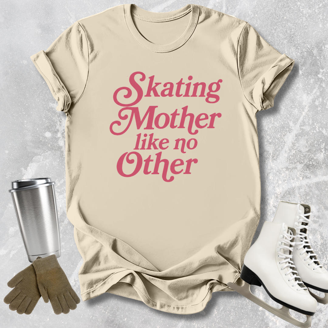 Beige t-shirt with pink text 'Skating Mother like no Other' on a textured surface with ice skates and a tumbler.