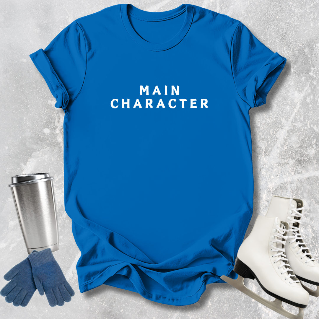 Blue t-shirt with 'MAIN CHARACTER' text, silver tumbler, blue gloves, and white skates on a textured gray background