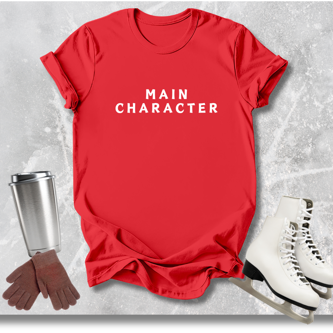 Red t-shirt with 'MAIN CHARACTER' text, white skates, brown gloves, and silver cup on a textured gray background