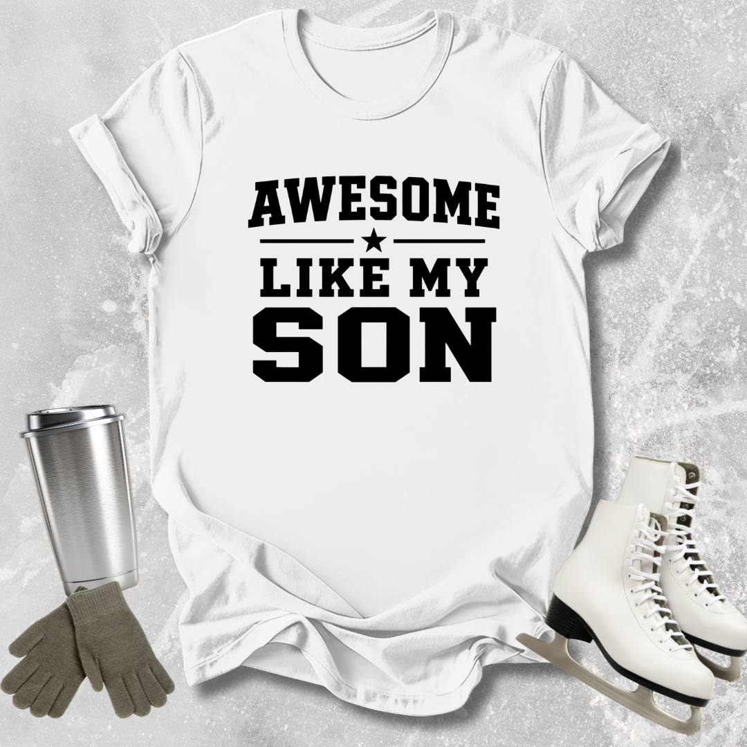 White t-shirt with 'Awesome like my son' text, next to a silver tumbler, green gloves, and white skates on a gray textured background.
