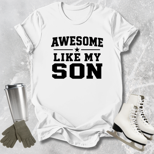 White t-shirt with 'Awesome like my son' text, next to a silver tumbler, green gloves, and white skates on a gray textured background.