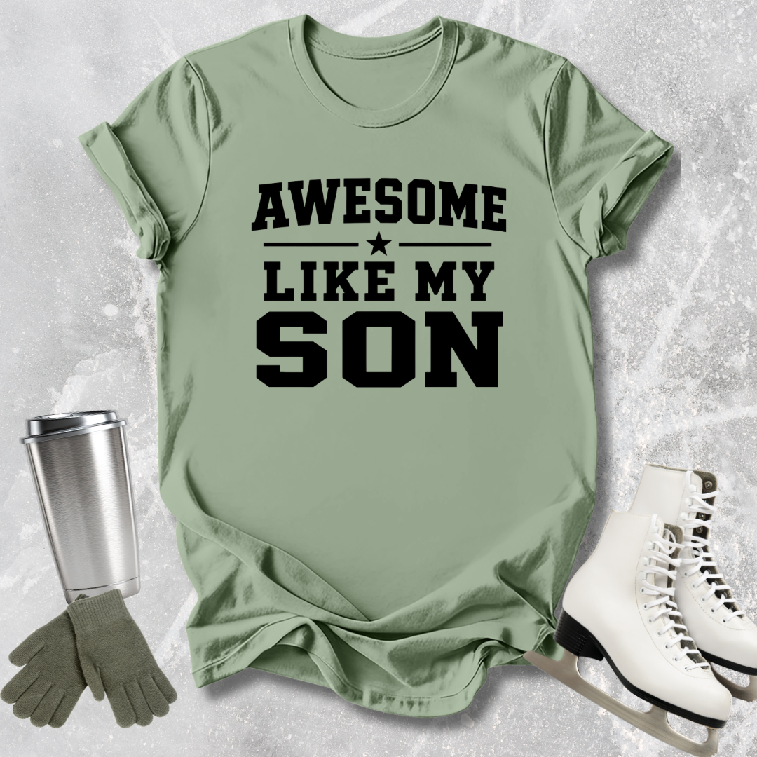 Green t-shirt with 'Awesome Like My Son' text, next to a silver tumbler, green gloves, and white skates on a textured surface.