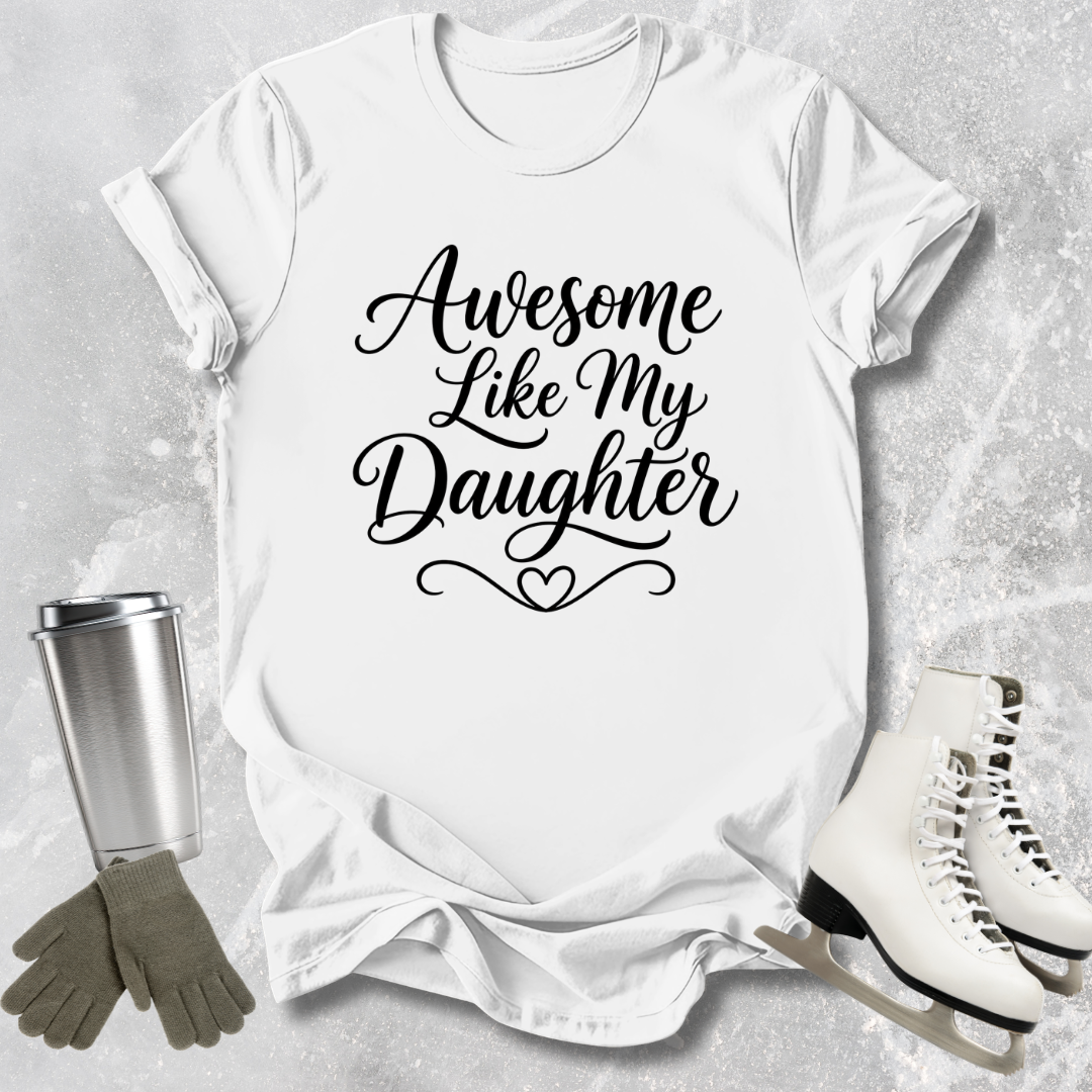 White t-shirt with 'Awesome Like My Daughter' text, next to a silver tumbler, green gloves, and white skates on a light gray background.