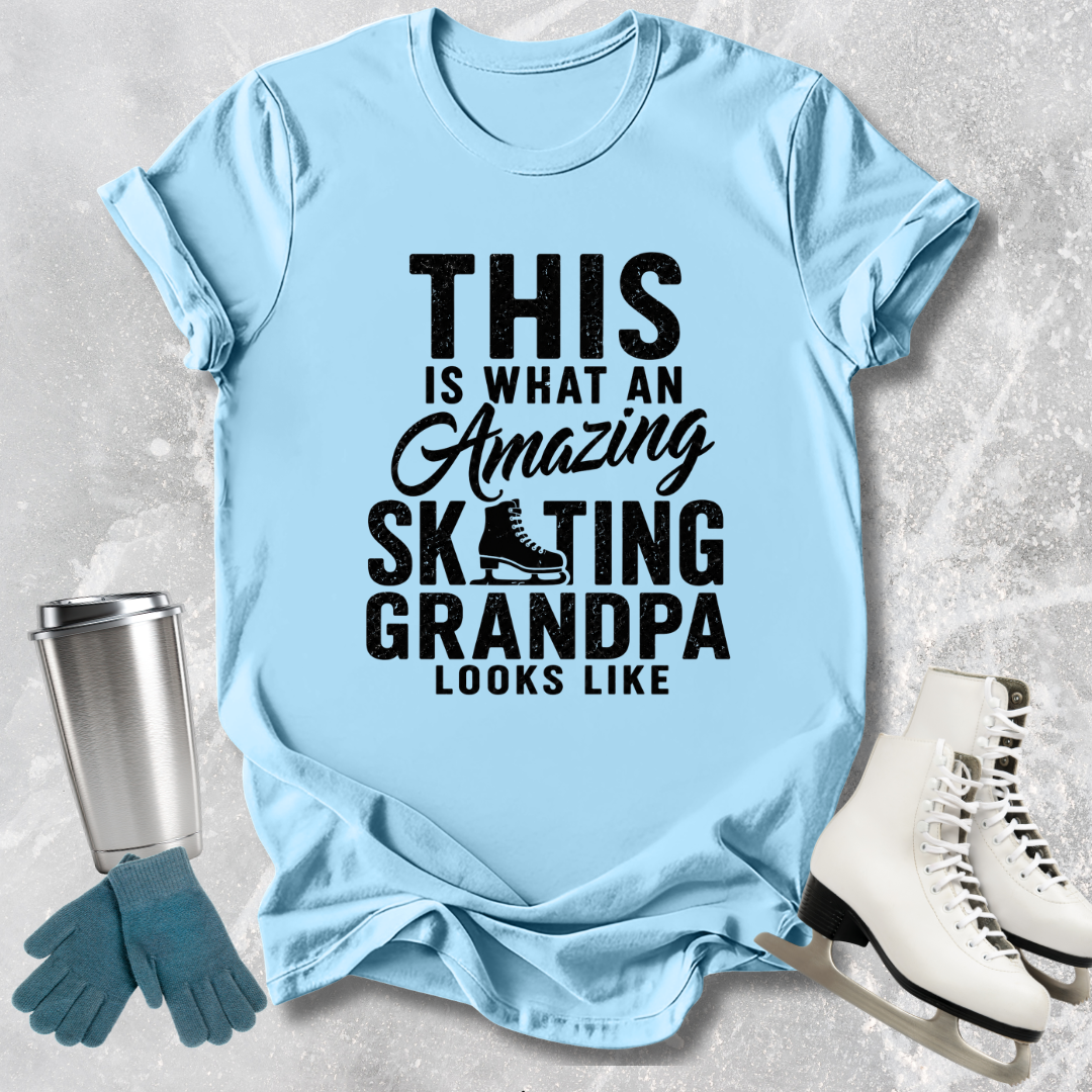 Light blue t-shirt with text 'This is what an amazing skating grandpa looks like' on a textured surface with accessories.