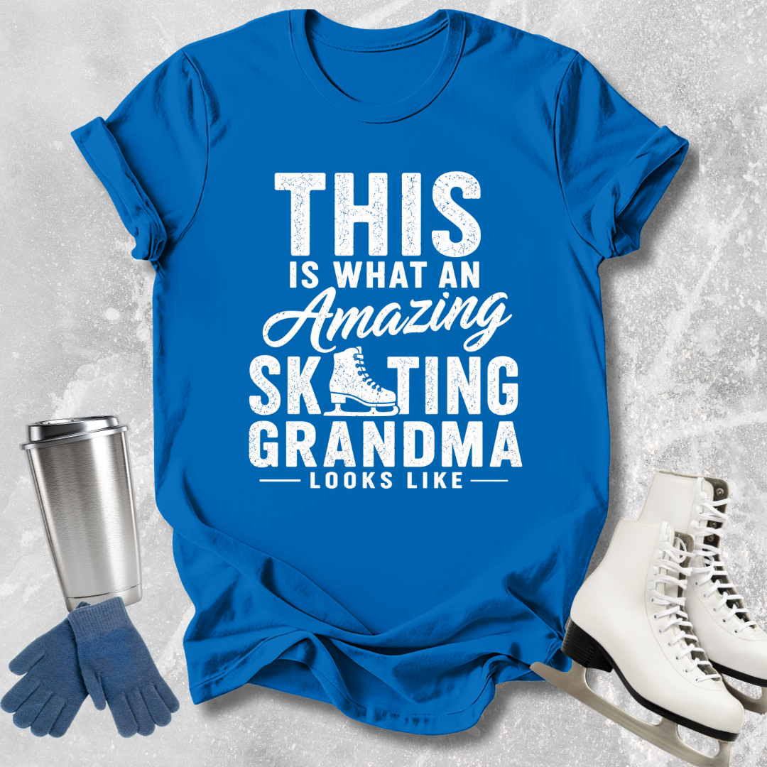 Blue t-shirt with text 'This is what an amazing skating grandma looks like' on a textured gray background.