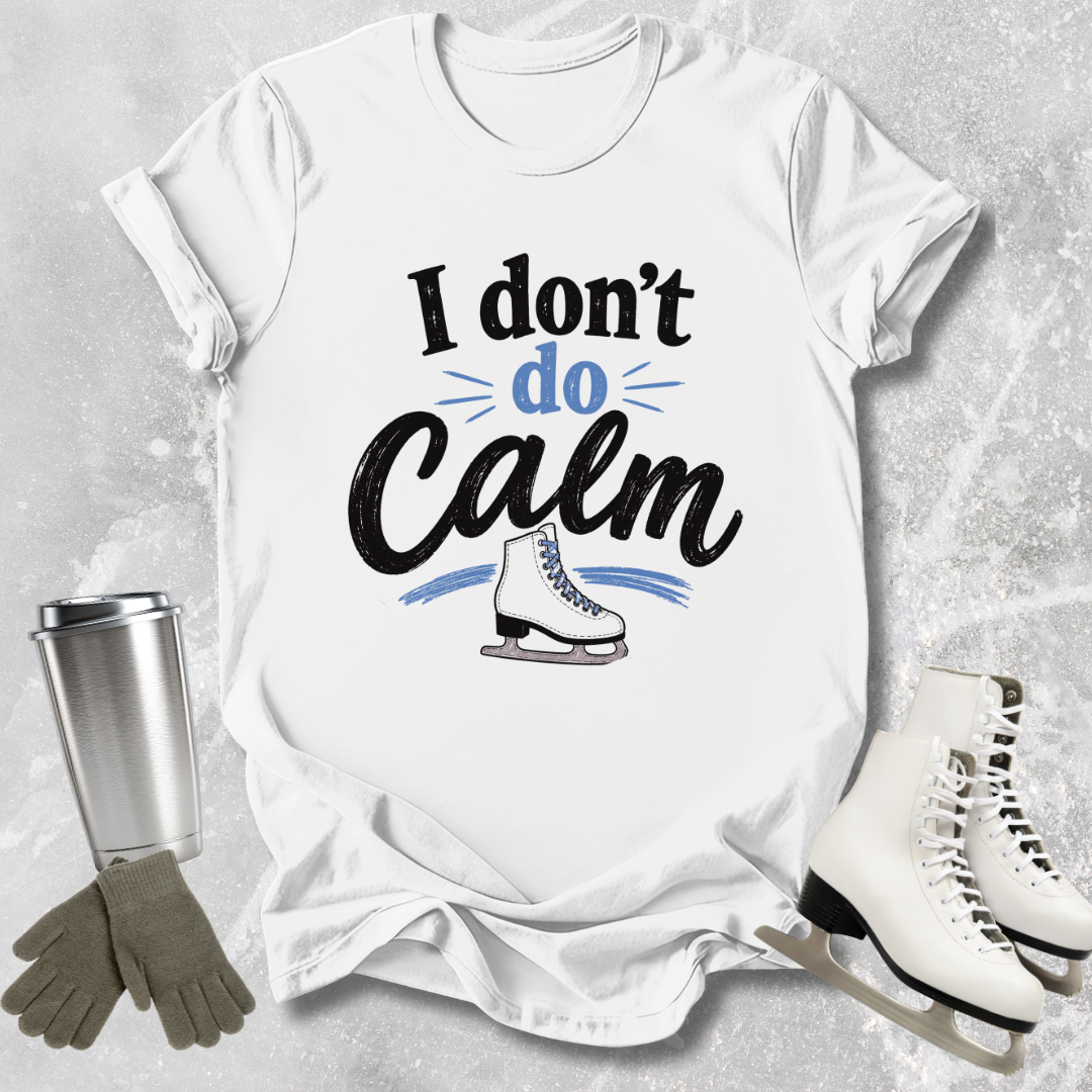 White t-shirt with 'I don't do Calm' text and ice skate graphic, surrounded by ice skates and a tumbler on a textured surface.