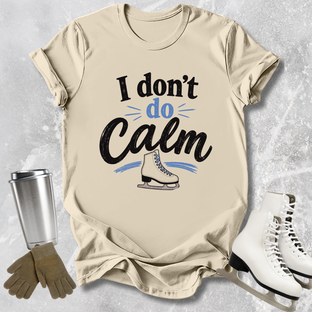 Beige t-shirt with 'I don't do Calm' text and ice skate graphic, surrounded by ice skates and a tumbler.
