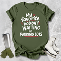 Green t-shirt with humorous text, paired with a silver tumbler, green gloves, and white shoes on a textured background.