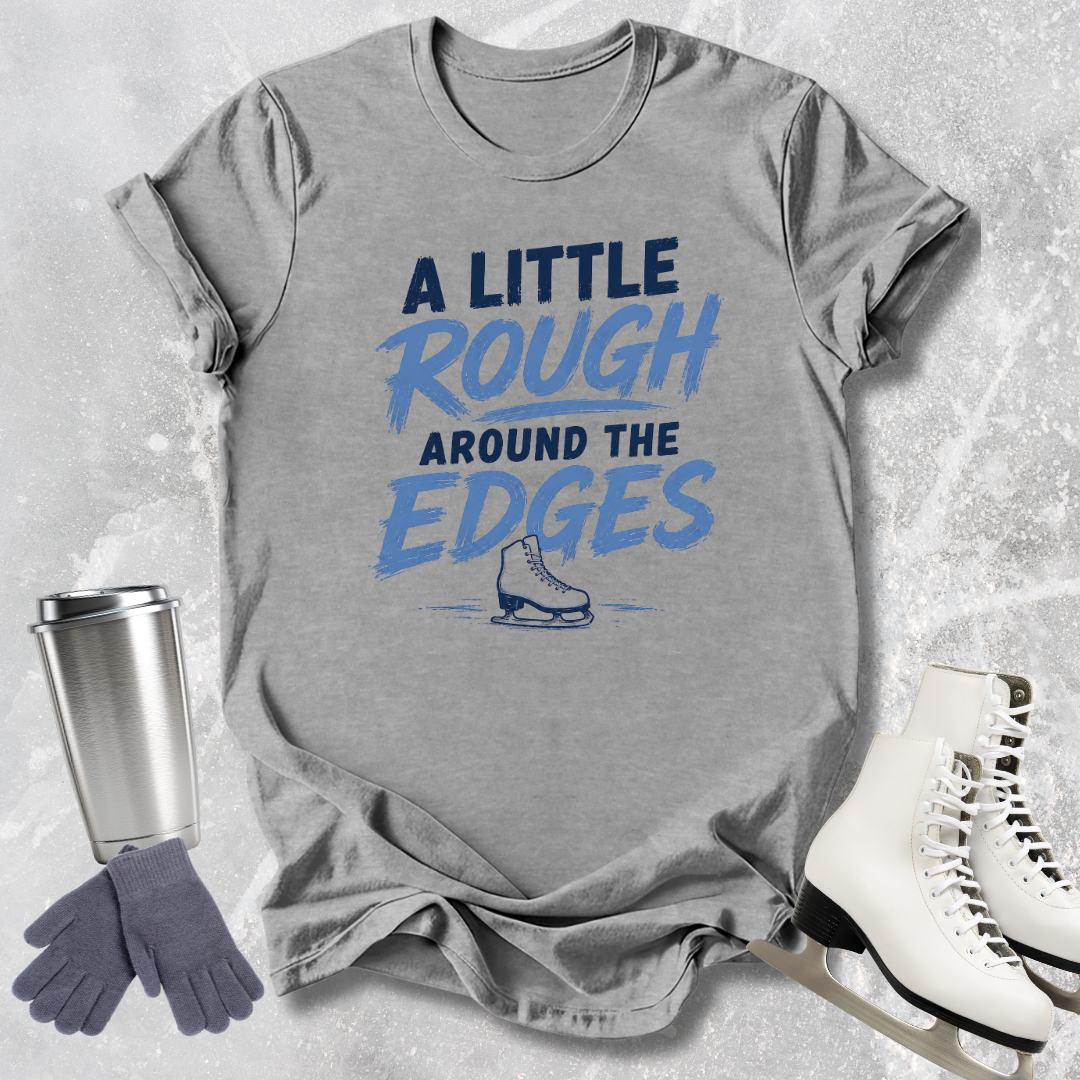 Gray t-shirt with blue text and graphics, paired with a silver tumbler, gray gloves, and white skates on a textured ice background.