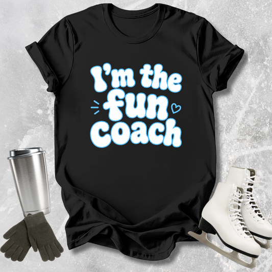 Black t-shirt with 'I'm the fun coach' text on a textured surface with accessories.