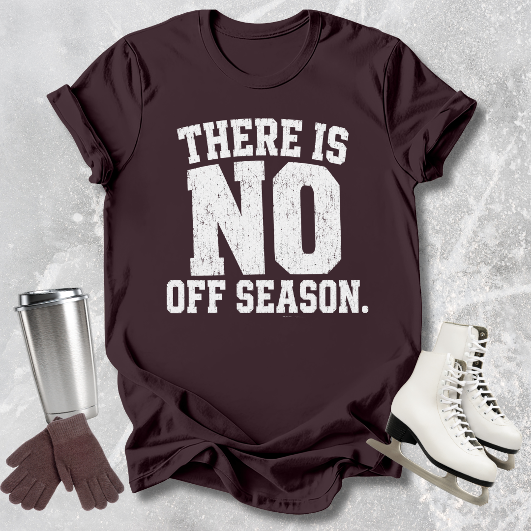 Maroon t-shirt with 'There is no off season' text, next to a silver tumbler, brown gloves, and white skates on a textured gray background.