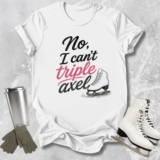 White t-shirt with 'No, I can't triple Axel' text, ice skates, gloves, and a tumbler on a textured surface.