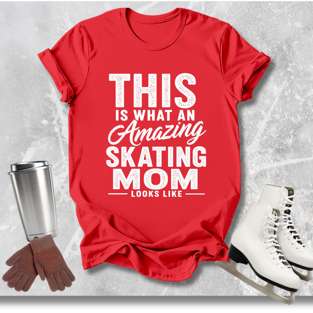 Red t-shirt with text 'This is what an amazing skating mom looks like' on a textured gray background with ice skates, gloves, and a cup.