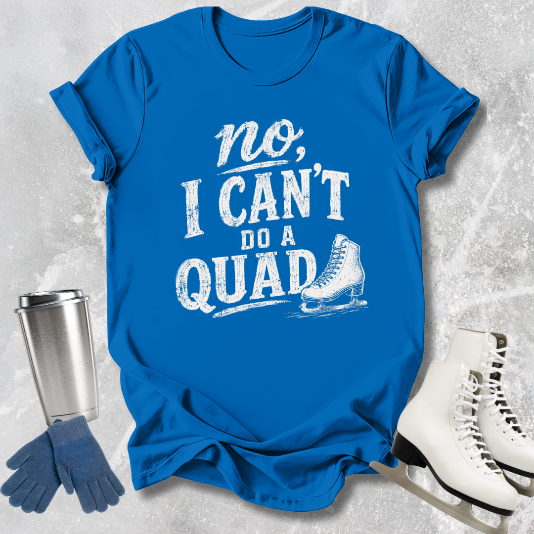 Blue t-shirt with 'no, I can't do a quad' text and ice skate graphic on a textured gray background.