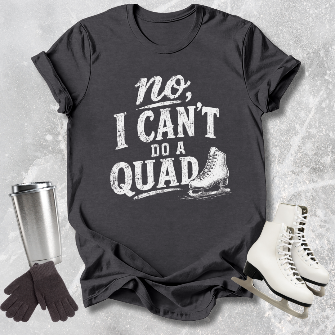 Gray t-shirt with 'no, I can't do a quad' text and ice skate graphic on a textured gray background.