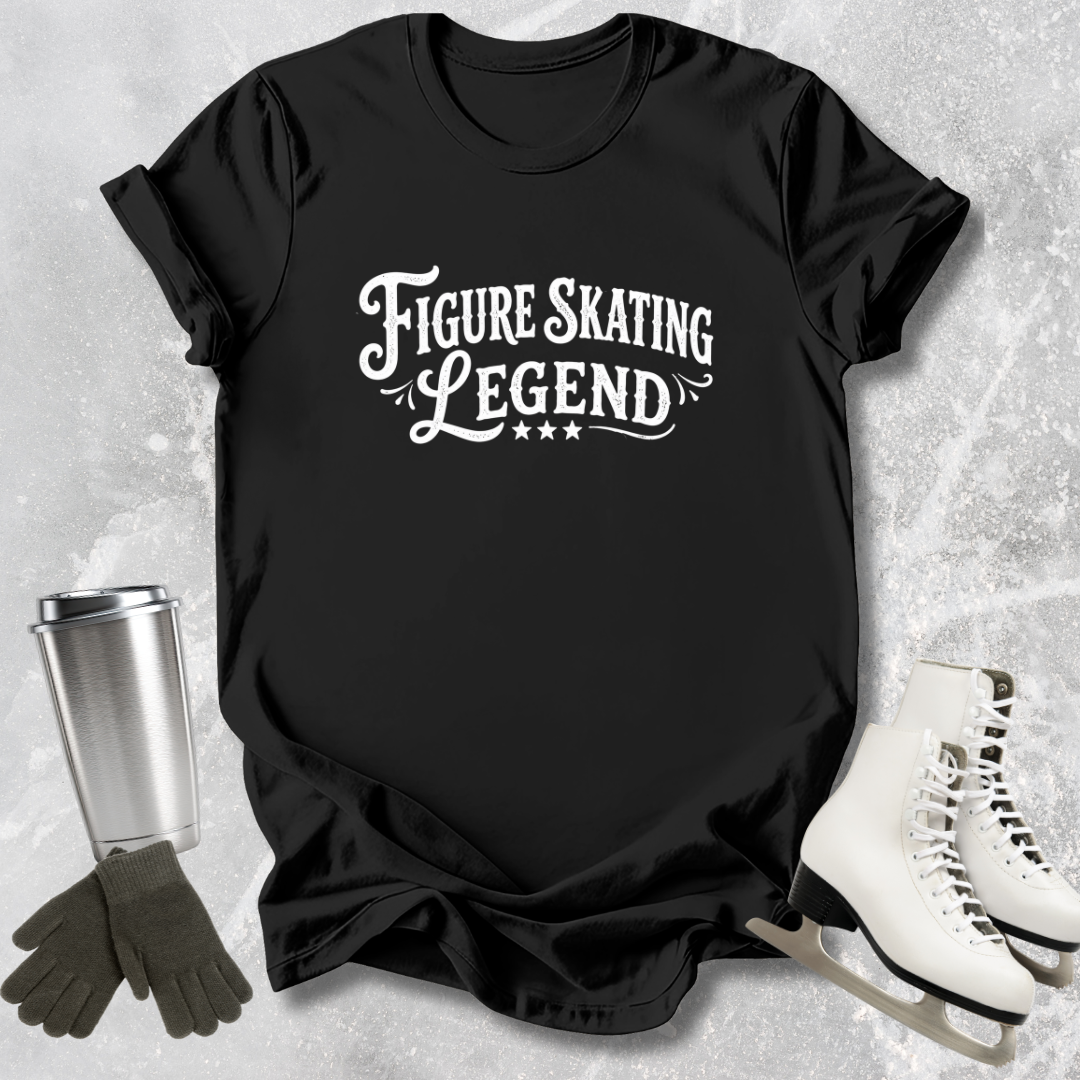 Black t-shirt with 'Figure Skating Legend' text, surrounded by ice skates and a tumbler on a textured gray background.