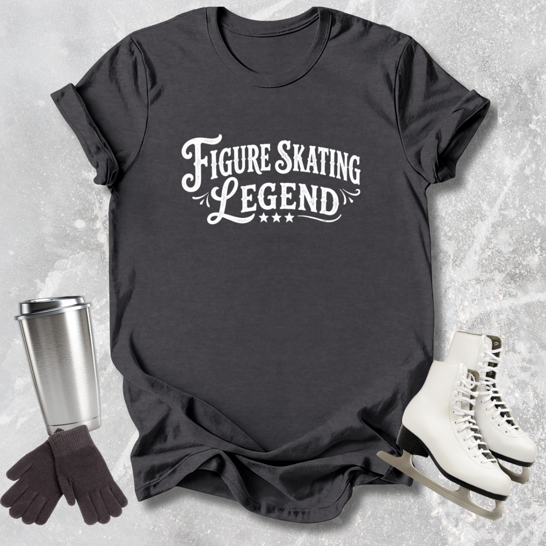Black t-shirt with 'Figure Skating Legend' text, next to a silver tumbler, black gloves, and white skates on a textured gray background.