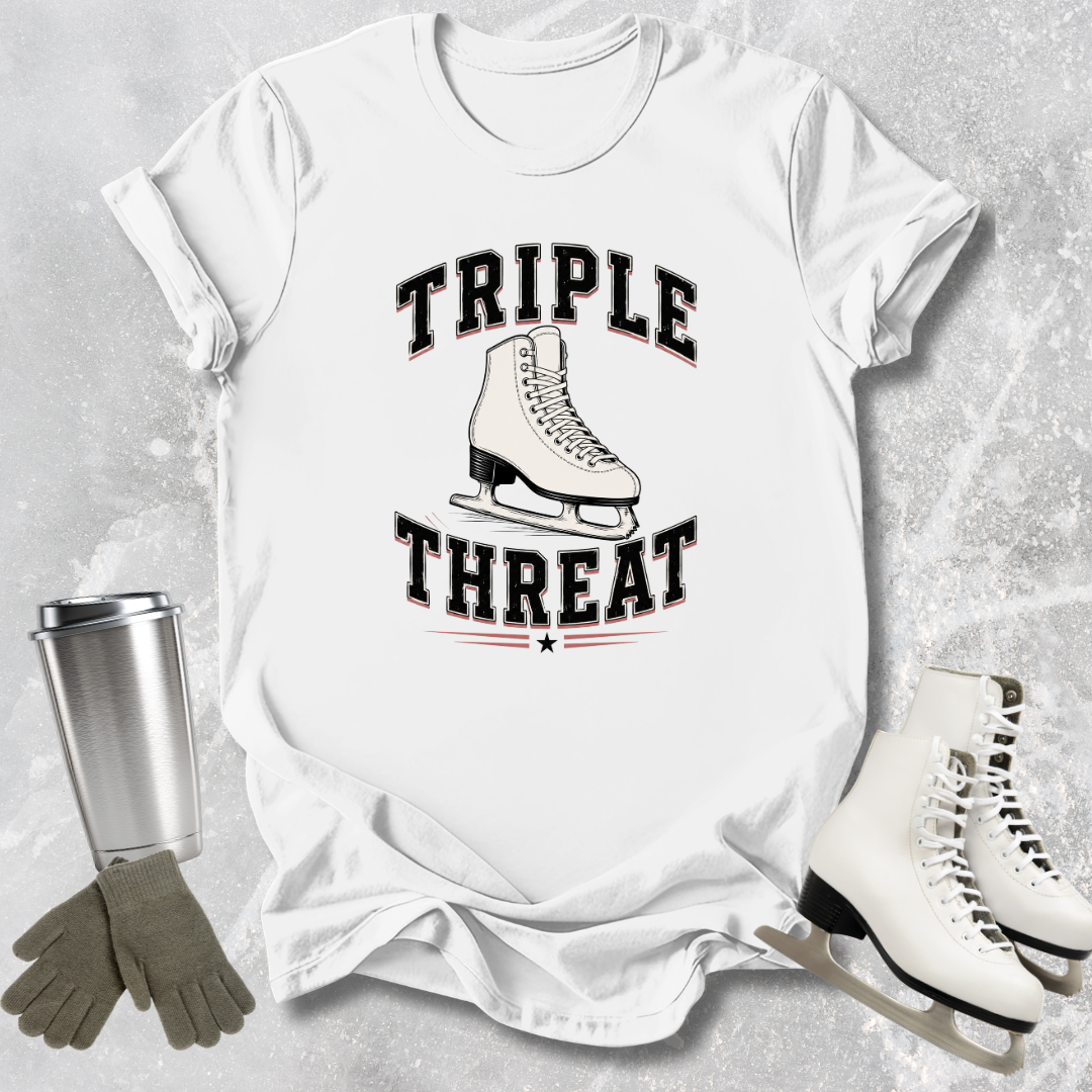 White t-shirt with 'Triple Threat' graphic, ice skates, gloves, and a tumbler on a textured surface.