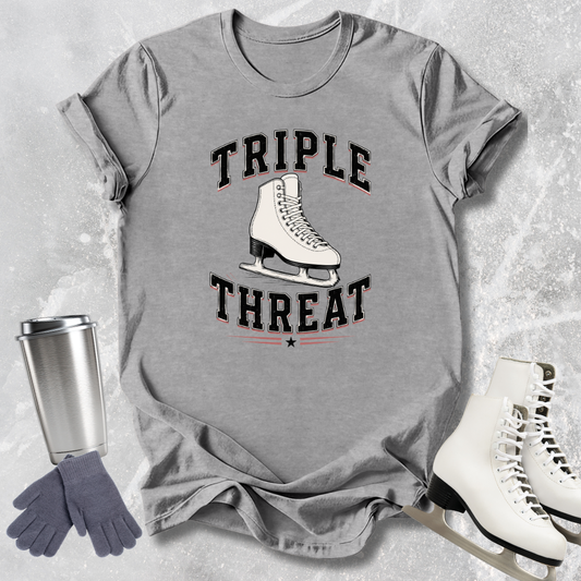 Gray t-shirt with 'Triple Threat' graphic, ice skates, gloves, and tumbler on a textured surface