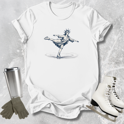 White t-shirt with a graphic design of a skater, next to white skates, gray gloves, and a silver tumbler on a textured surface.