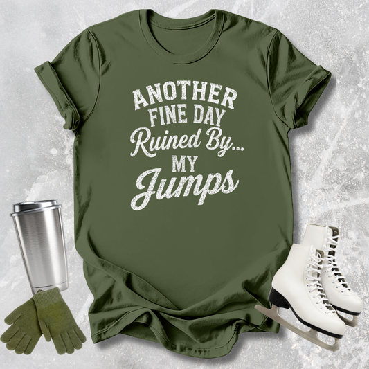 Green t-shirt with text 'Another fine day ruined by my jumps' on a textured surface with accessories.