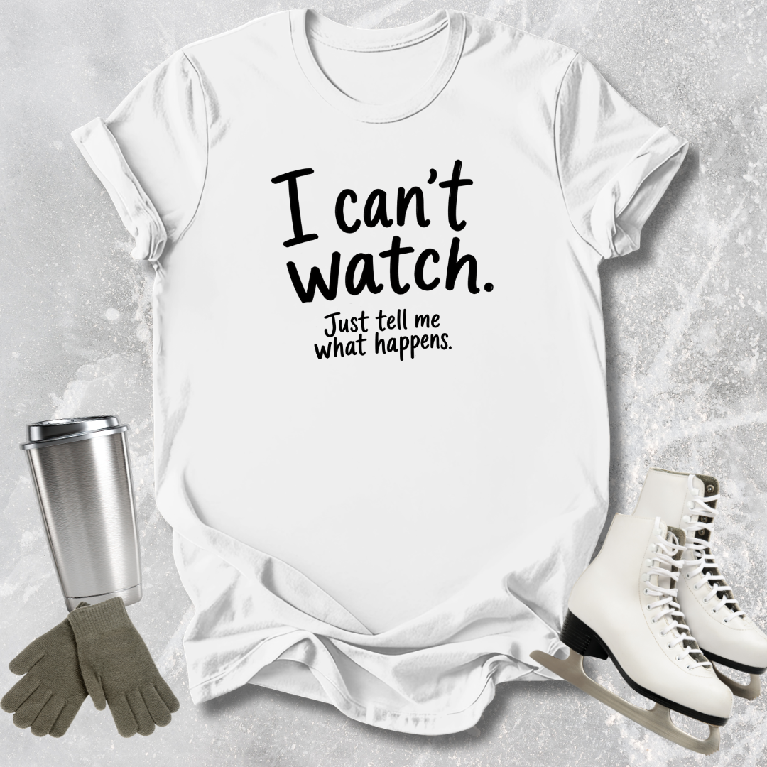 White t-shirt with text 'I can't watch. Just tell me what happens.' on a textured surface with accessories.