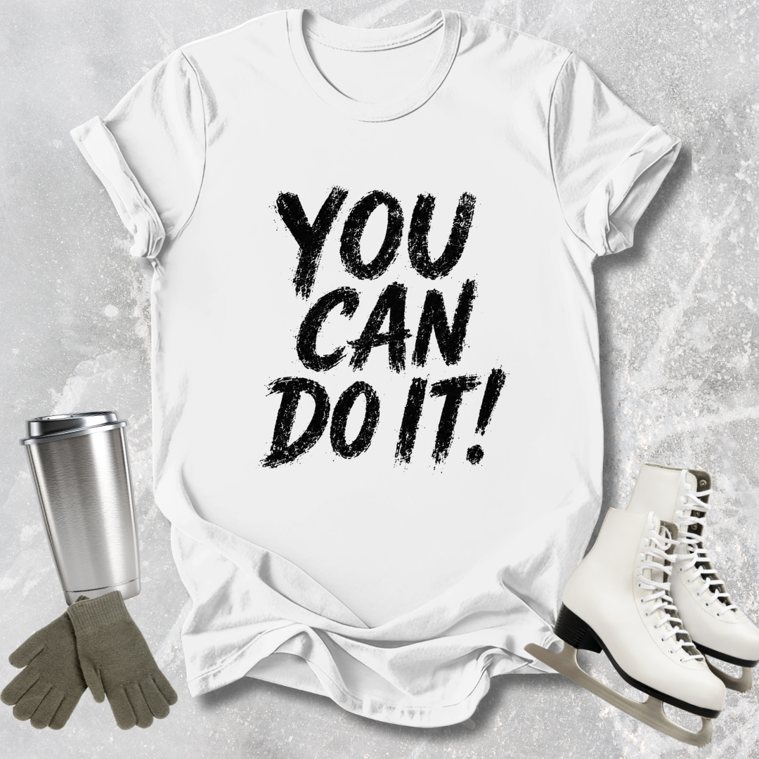 White t-shirt with 'You Can Do It!' text, silver tumbler, gray gloves, and white skates on a light gray background