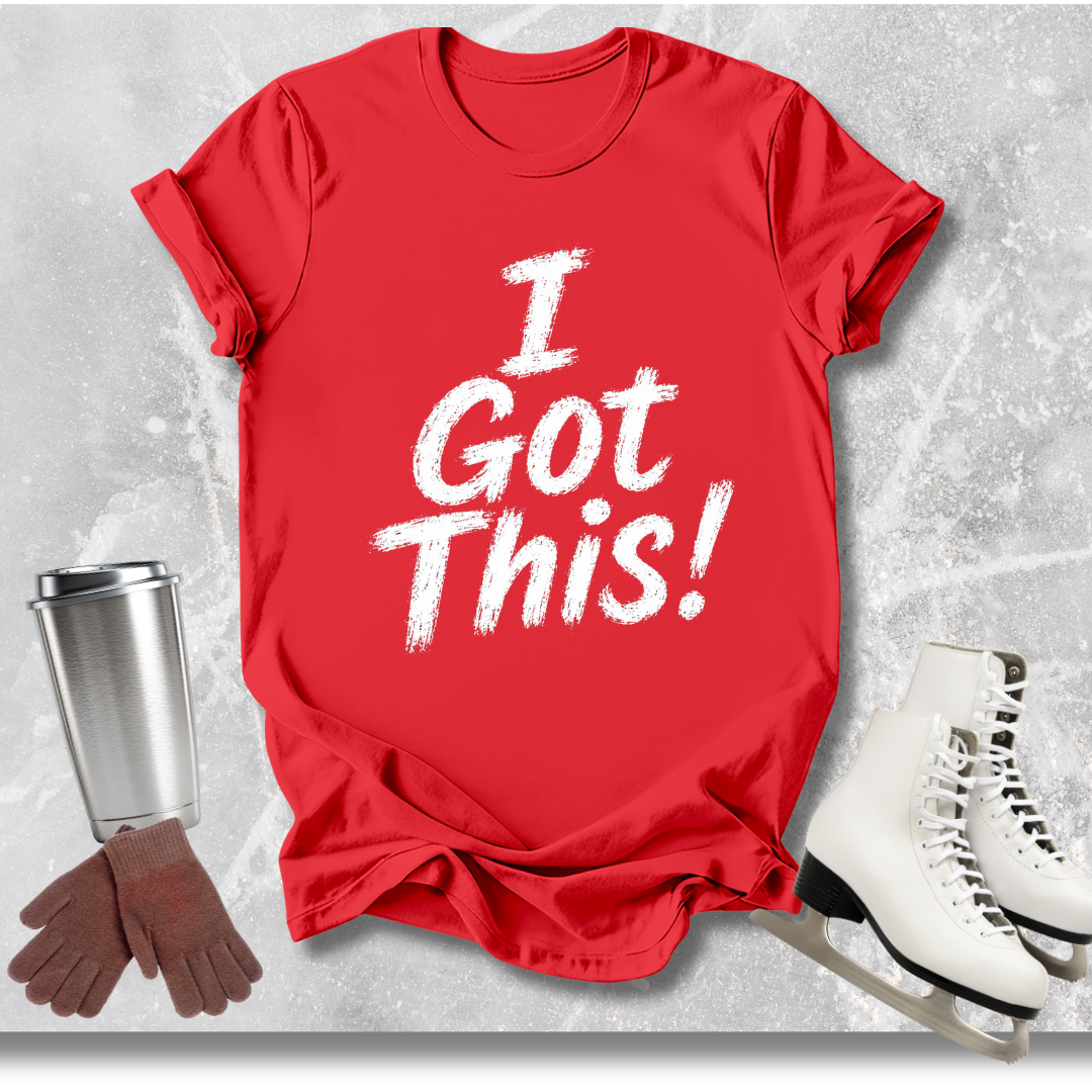 Red t-shirt with 'I Got This!' text, next to a silver tumbler, gloves, and white skates on a textured gray background.