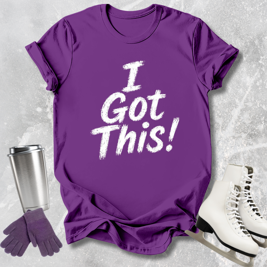 Purple t-shirt with 'I Got This!' text, silver tumbler, purple gloves, and white skates on a textured gray background