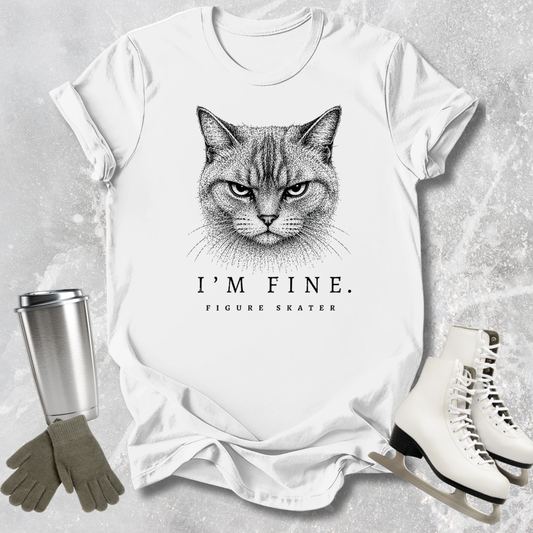 White t-shirt with a cat graphic and text, surrounded by a tumbler, gloves, and figure skates on a textured surface.