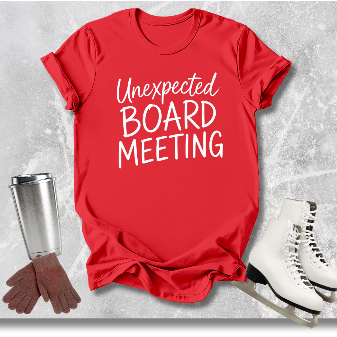 Red t-shirt with 'Unexpected Board Meeting' text, next to a silver tumbler, brown gloves, and white skates on a light gray background.