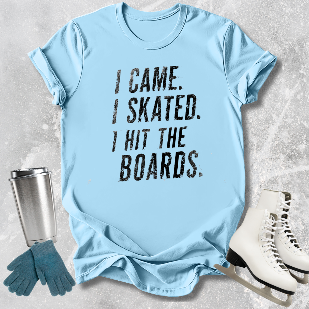 Light blue t-shirt with 'I Came. I Skated. I Hit the Boards.' text, next to ice skates and a tumbler on a textured surface.
