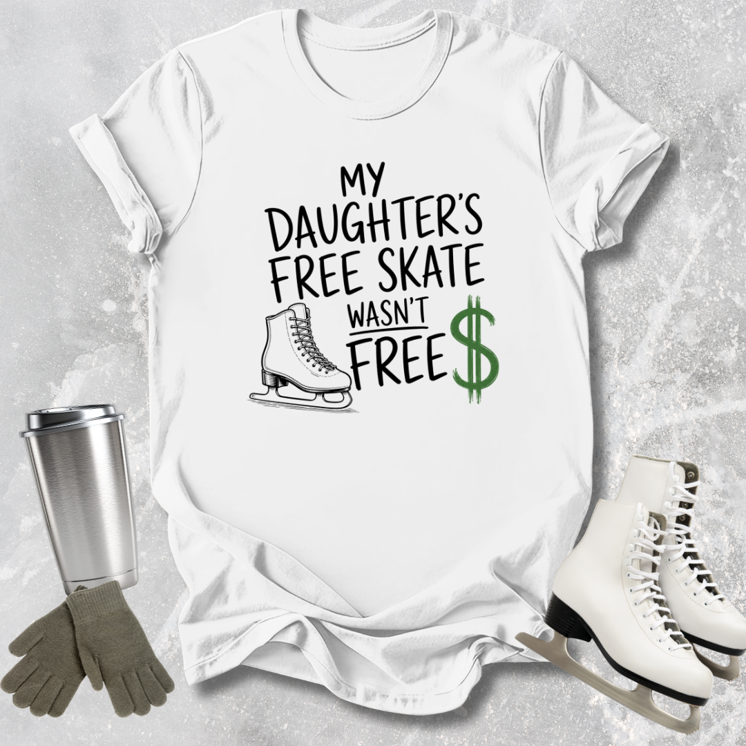 White t-shirt with text 'My Daughter's Free Skate Wasn't Free' on a textured gray background, with ice skates and gloves.