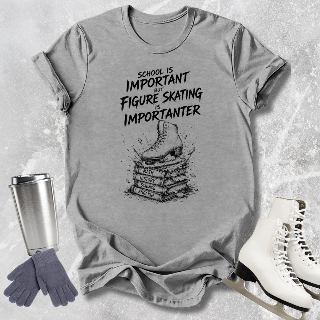 Gray t-shirt with figure skating graphic and text, surrounded by ice skates, gloves, and a tumbler.