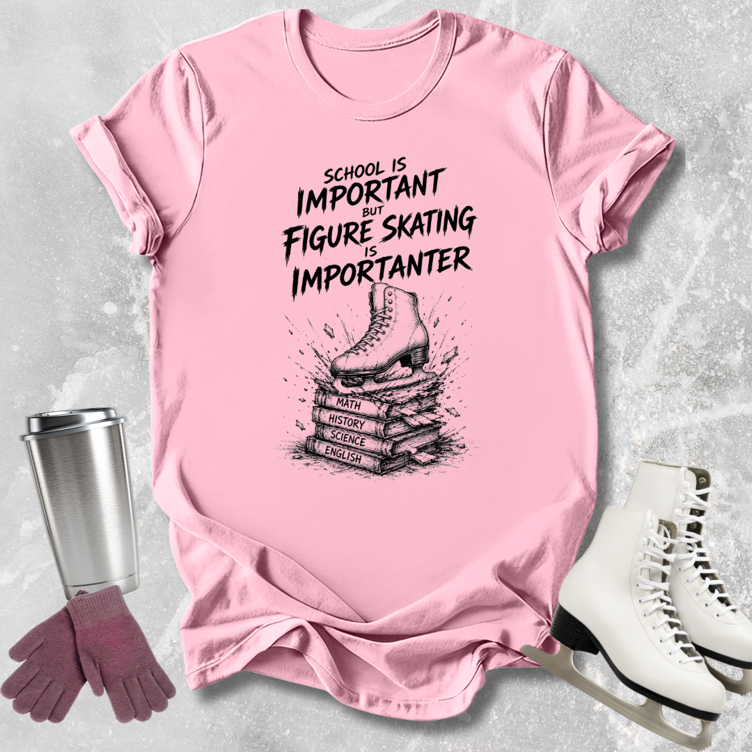 Pink t-shirt with figure skating design and text, surrounded by skates, gloves, and a tumbler on a gray background.