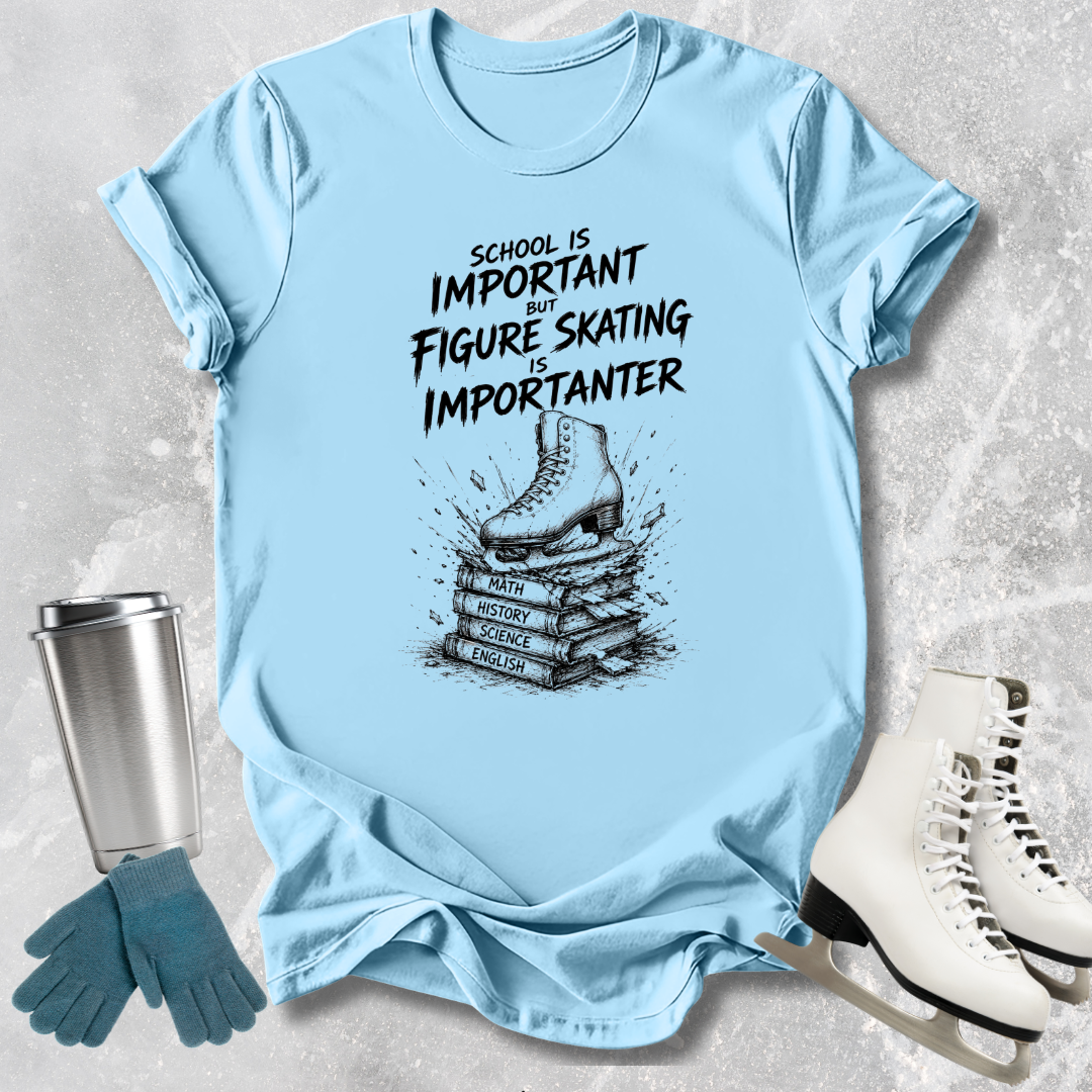 Light blue t-shirt with figure skating design and text, surrounded by ice skates and a tumbler.
