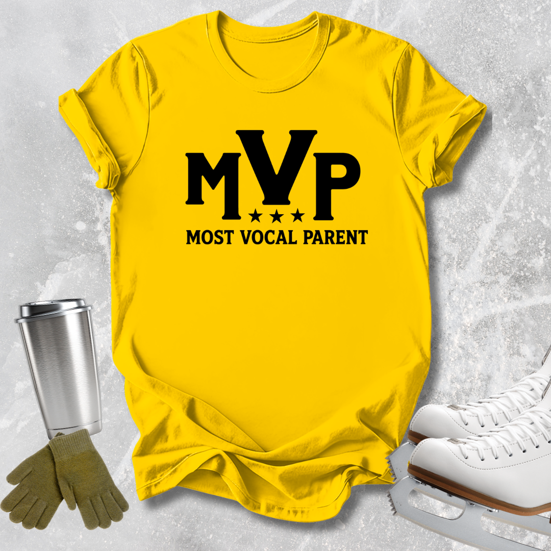 A bright yellow graphic t-shirt featuring the black text 'MVP MOST VOCAL PARENT' with stars, styled in a flat-lay arrangement with ice skates, gloves, and a metal cup on a light gray textured background.
