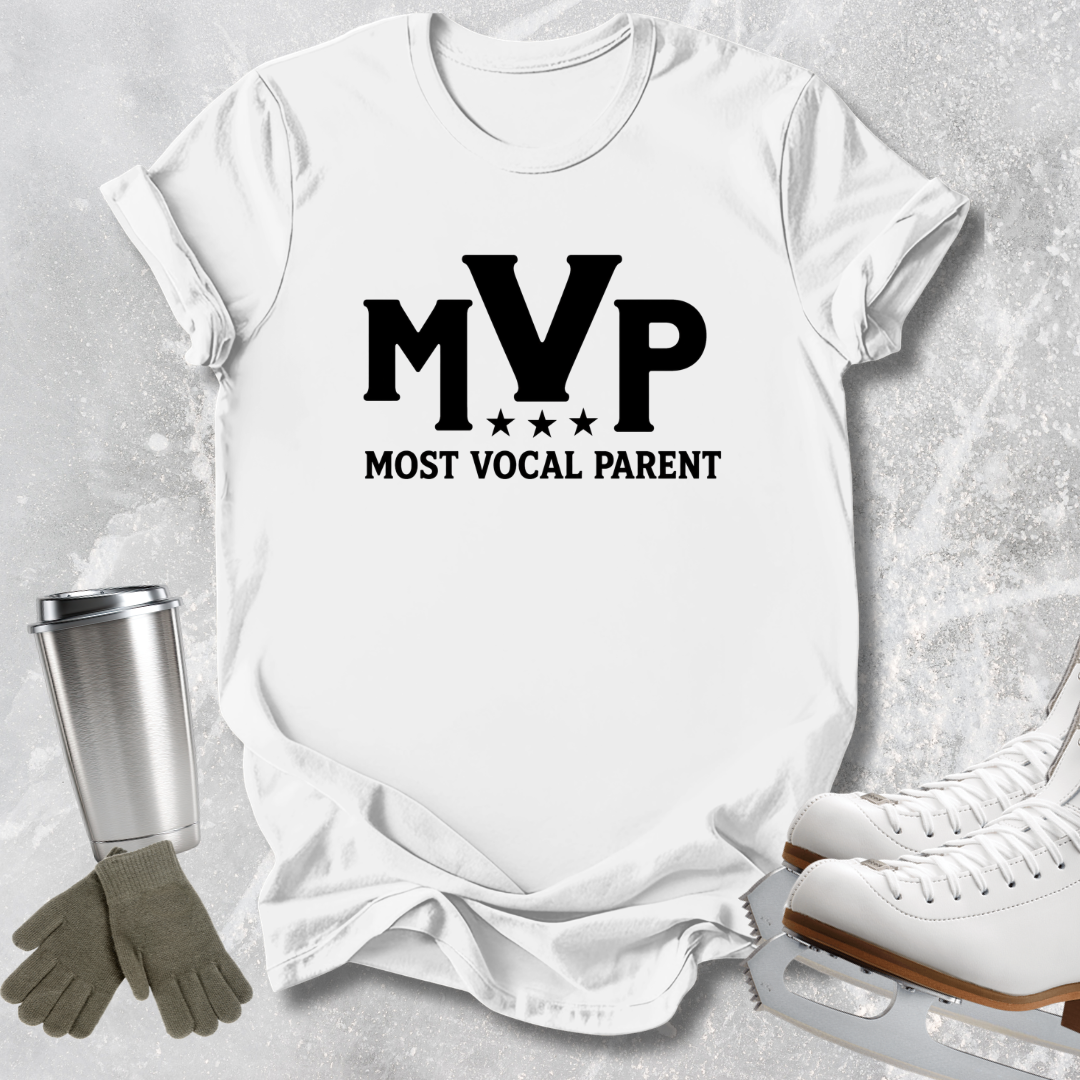 A white short-sleeve T-shirt laid flat on a light textured background, printed with large black 'MVP' lettering and the phrase 'MOST VOCAL PARENT' beneath it. A stainless steel tumbler, gray gloves, and white ice skates are placed around the shirt as styled props.