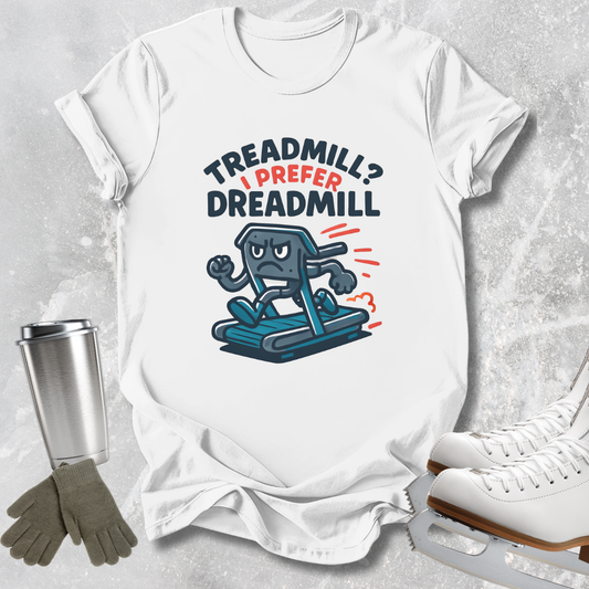 A white graphic t-shirt laid flat on a light gray textured surface, featuring the text 'TREADMILL? I PREFER DREADMILL' in dark blue and red, with a cartoon treadmill character. White ice skates, a metal tumbler, and gray gloves are styled around the shirt.