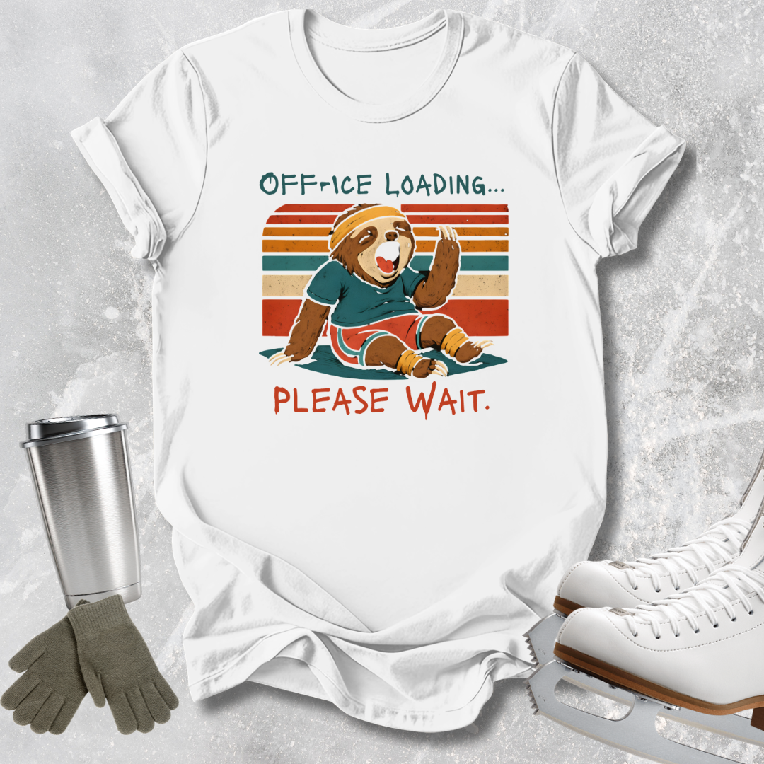 A white graphic T-shirt laid flat on a light gray textured surface, with a vintage-style cartoon sloth sitting in front of retro stripes and the text 'OFFICE LOADING.