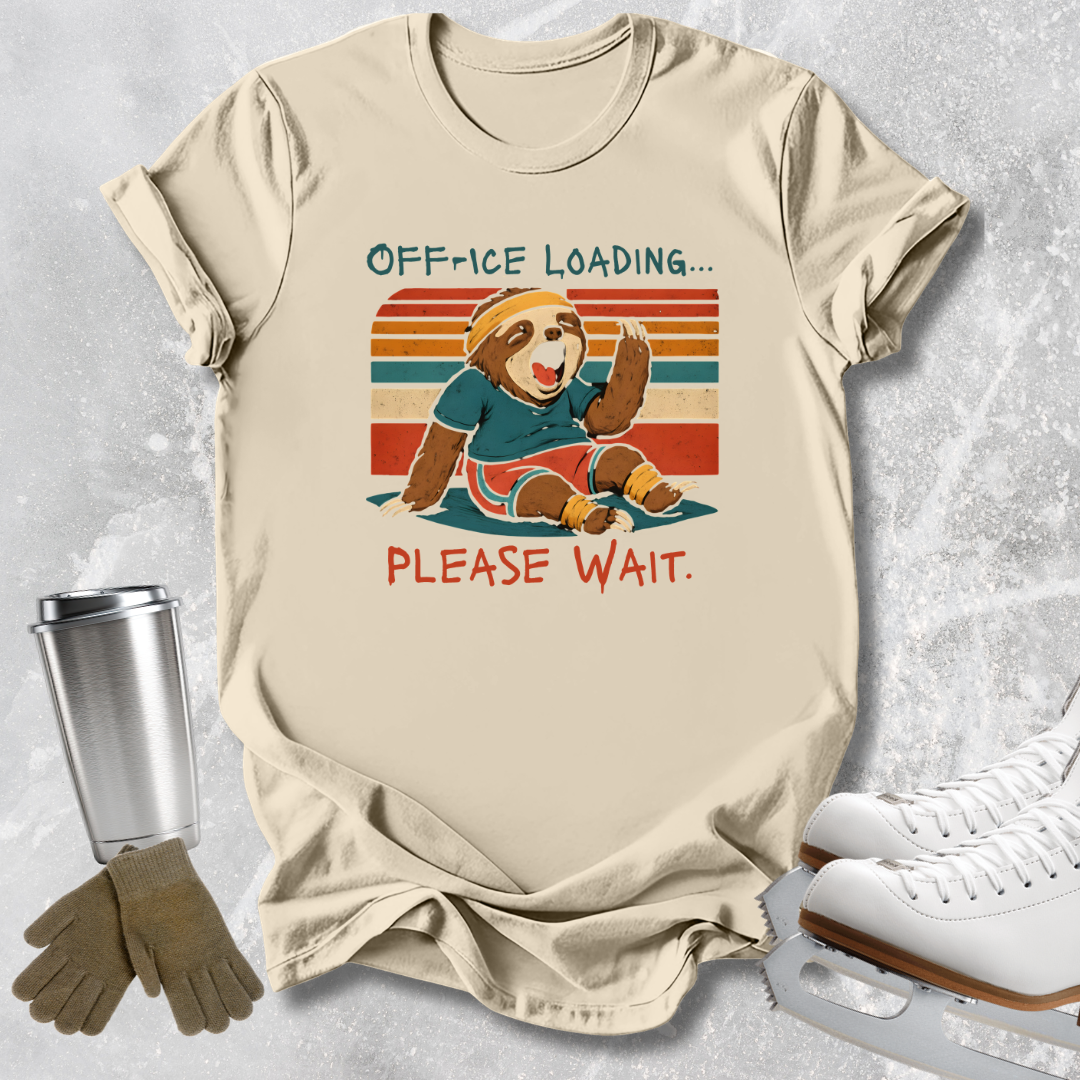 A beige graphic t-shirt laid flat on a light gray textured surface, featuring a retro-style illustration of a sloth wearing hockey gear with the text 'OFF-ICE LOADING.