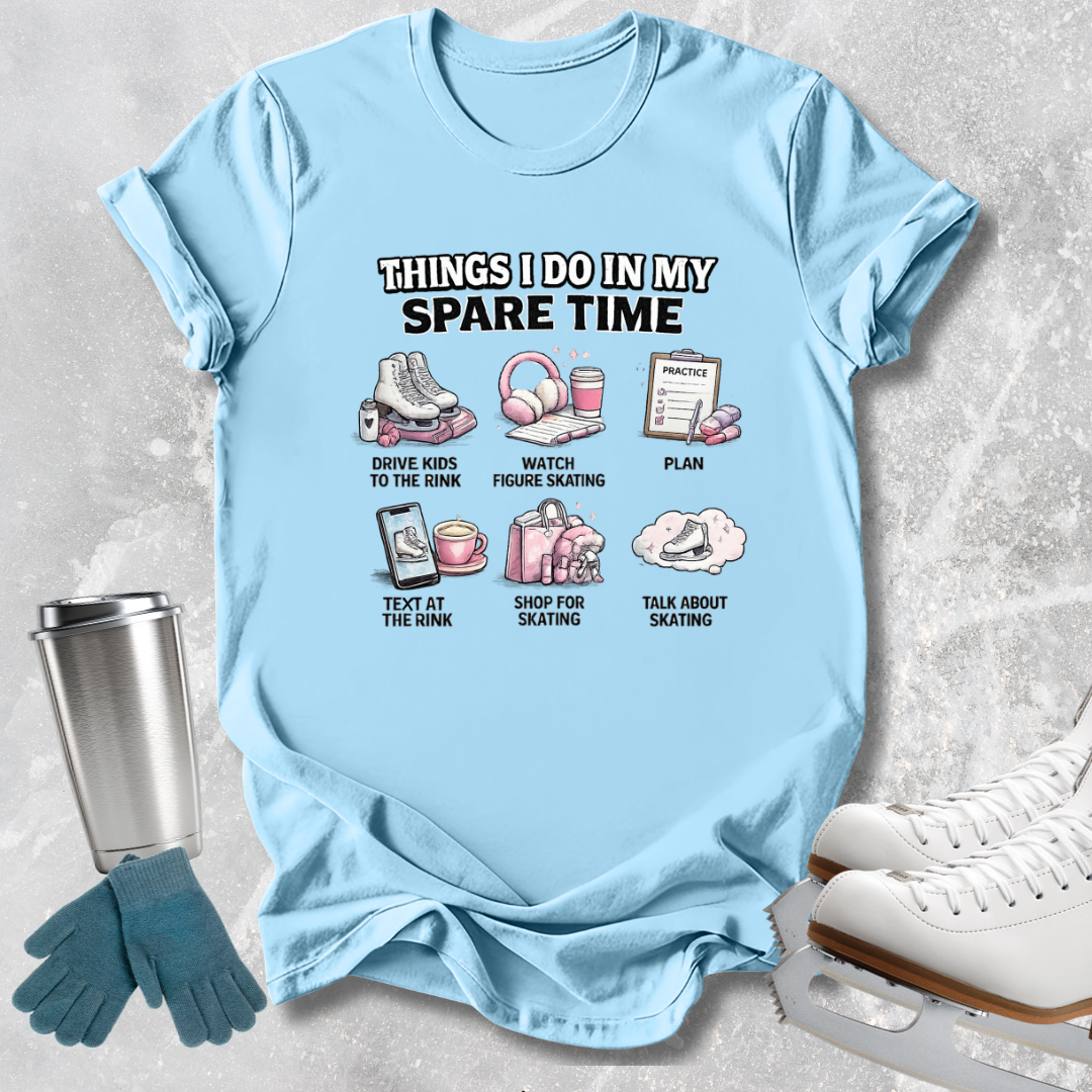 A light blue graphic t-shirt laid flat on a textured light gray background, surrounded by ice skating props including white ice skates, blue gloves, and a metal tumbler. The t-shirt features a printed graphic with the text 'THINGS I DO IN MY SPARE TIME' and six small illustrations with labels related to ice skating.
