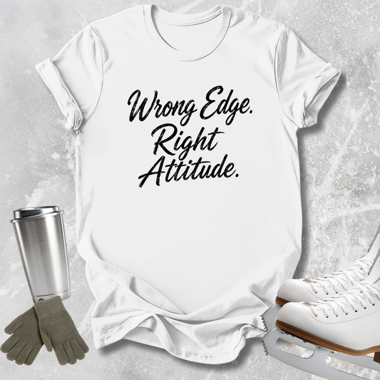 A white short-sleeve T-shirt laid flat on a light gray textured surface, printed with the phrase 'Wrong Edge. Right Attitude.