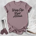 A mauve short-sleeve graphic T-shirt laid flat on a light gray textured surface, with the phrase 'Wrong Edge. Right Attitude.