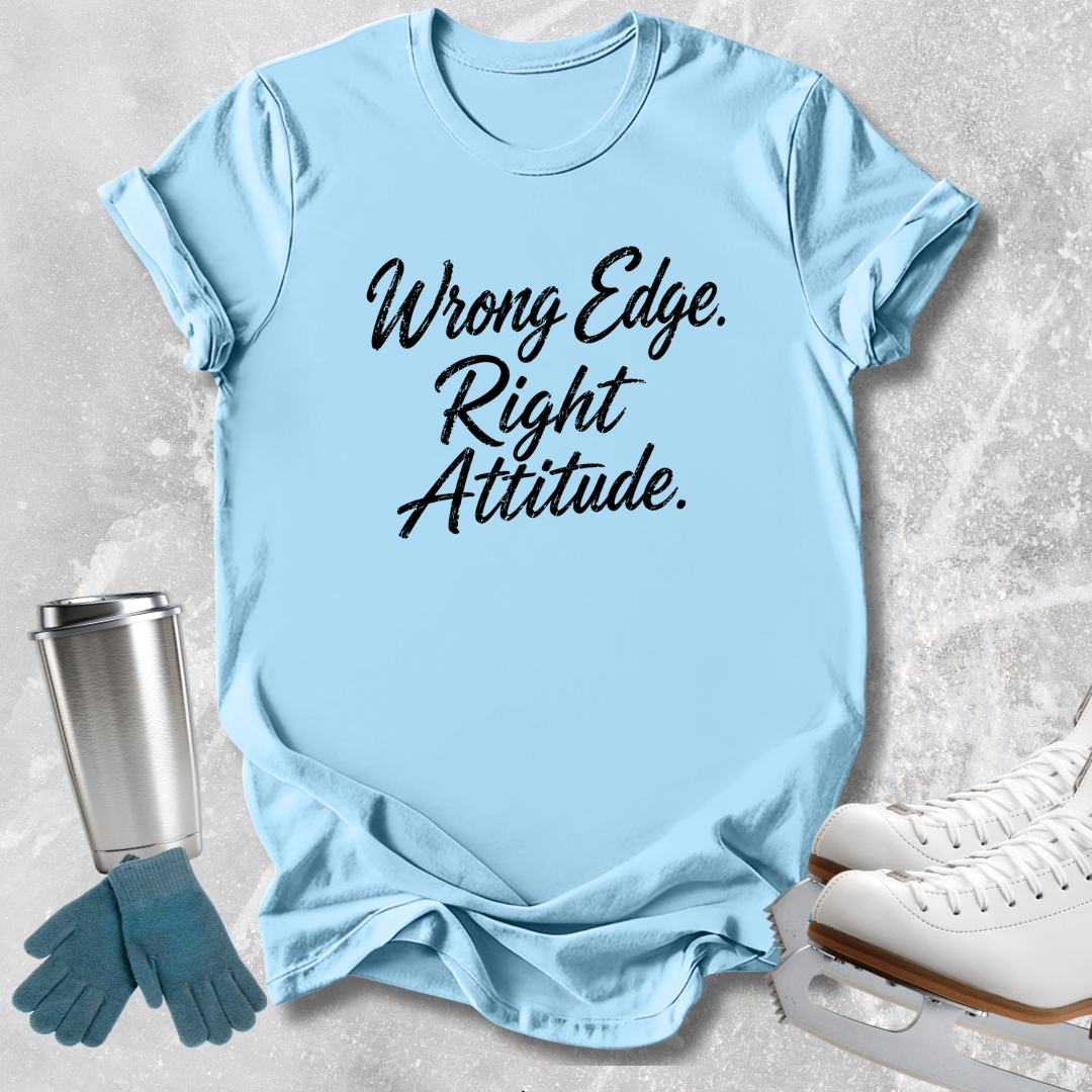 A light blue graphic T-shirt laid flat on a textured light gray surface, with the phrase 'Wrong Edge. Right Attitude.
