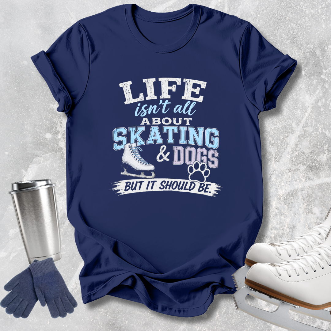 A navy blue graphic t-shirt laid flat on a light gray textured background, featuring the text 'LIFE isn't all ABOUT SKATING & DOGS BUT IT SHOULD BE.' in white and light blue, alongside a skate boot graphic and paw print.